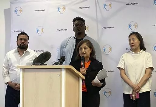 Chanda Parbhoo, at podium, founder and president of SAAVETX Education Fund, speaks at a news conference as, from left rear, Ramiro Luna, executive director and co-founder of Somos Tejas; Jerry Hawkins of Dallas Truth, Racial Healing & Transformation; and community member Caroline Kim listen, Monday, May 15, 2023, in Dallas. Members of Texas groups representing people of color demanded that authorities quickly acknowledge whether they believe the neo-Nazi who killed eight people at a Dallas-area 
