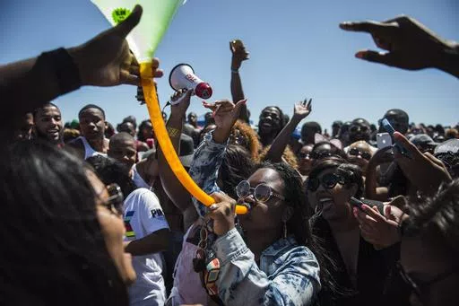 A crowd of party-goers cheer for a woman drinking from a beer bong during Orange Crush on Tybee Island, Ga., April 16, 2016. Thousands of Black college students expected this weekend for an annual spring bash at Georgia's largest public beach shouldn't expect a warm welcome. Tybee Island's city leaders are bringing in dozens of extra police officers and using barricades to block parking lots and residential streets during Orange Crush, a sprawling beach party begun three decades ago. (Josh Galem