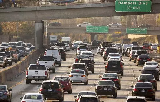 This Dec. 12, 2018, file photo shows traffic on the Hollywood Freeway in Los Angeles. New vehicles sold in the U.S. will have to travel an average of at least 40 miles per gallon of gasoline in 2026 under new rules unveiled by the government. The National Highway Traffic Safety Administration said Friday its fuel economy requirements will undo a rollback enacted under President Donald Trump. (AP Photo/Damian Dovarganes, File)