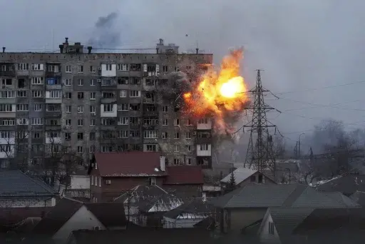 An explosion is seen in an apartment building after Russian's army tank fires in Mariupol, Ukraine, Friday, March 11, 2022. (AP Photo/Evgeniy Maloletka, File)