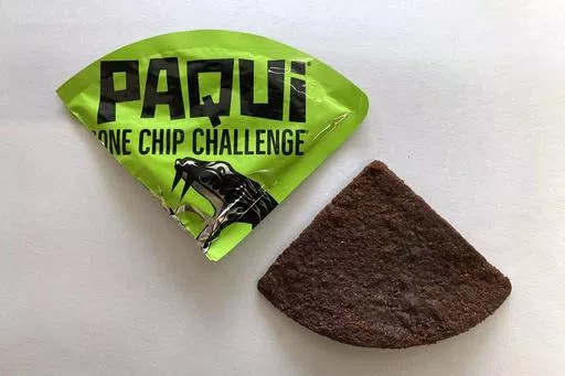 A Paqui One Chip Challenge chip is displayed in Boston, Friday, Sept. 8, 2023. A medical examiner says a Massachusetts teen who participated in a spicy tortilla chip challenge died from ingesting a substance “with a high capsaicin concentration,” according to autopsy results The Associated Press obtained late Wednesday, May 15, 2024. Capsaicin is a chili pepper extract. Harris Wolobah died on Sept. 1, 2023, after eating the chip. (AP Photo/Steve LeBlanc, File)