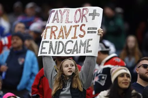 A fan displays a sign that calls attention to Taylor Swift and Kansas City Chiefs tight end Travis Kelce during the second half of an NFL football game between the Chiefs and the New England Patriots, Sunday, Dec. 17, 2023, in Foxborough, Mass. (AP Photo/Michael Dwyer, File)