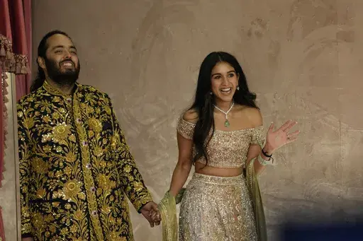 Anant Ambani, left, and Radhika Merchant pose for photographers during their pre-wedding ceremony in Mumbai, India, Friday, July 5, 2024. (AP Photo/Rajanish Kakade, File)
