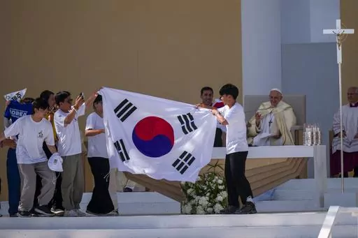 Young pilgrims from South Korea celebrate with their national flag and with Pope Francis after he announced that the next World Youth Day, will be in Seoul, South Korea in 2027, at the end of a mass at Parque Tejo in Lisbon, Sunday, Aug. 6, 2023. An estimated 1.5 million young people filled the parque on Saturday for Pope Francis' World Youth Day vigil, braving scorching heat to secure a spot for the evening prayer and to camp out overnight for his final farewell Mass on Sunday morning. (AP Phot