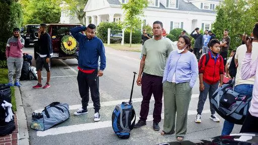 Migrants, who arrived on a flight sent by Florida Gov. Ron DeSantis, gather with their belongings outside St. Andrews Episcopal Church, Wednesday Sept. 14, 2022, in Edgartown, Mass., on Martha's Vineyard. A Texas sheriff on Monday, Sept. 19 opened an investigation into two flights of migrants sent to Martha's Vineyard by DeSantis, but did not say what laws may have been broken in putting 48 Venezuelans on private planes last week from San Antonio. (Ray Ewing/Vineyard Gazette via AP, File)