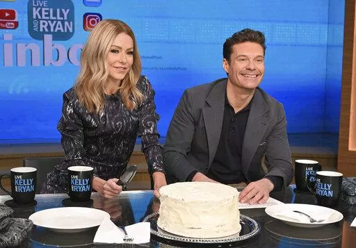 This image released by ABC shows co-host Kelly Ripa, left, and Ryan Seacrest on the set of "Live! With Kelly and Ryan" on Feb. 8, 2023 in New York. Seacrest has revealed he’s leaving the show this spring. Seacrest ends a six-year run alongside Ripa and his replacement will be her real-life husband, Mark Consuelos. (Lorenzo Bevilaqua/ABC via AP)