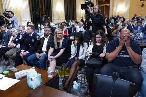 U.S. Capitol Police Sgt. Harry Dunn, right, and others react as the House select committee investigating the Jan. 6 attack on the U.S. Capitol holds its first public hearing to reveal the findings of a year-long investigation, at the Capitol in Washington, Thursday, June 9, 2022. (AP Photo/Andrew Harnik)
